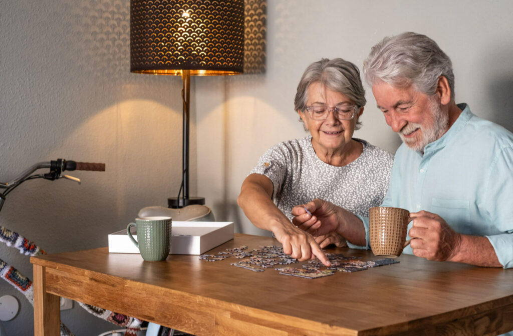 A senior man and a senior woman playing jigsaw puzzles.