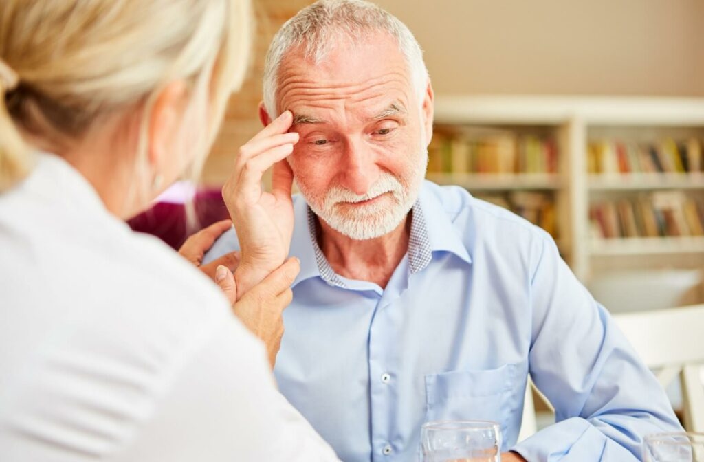 Senior man looking distressed while receiving comfort from a tax advisor. 