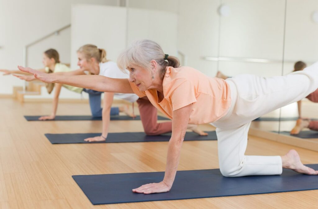 A group of seniors enjoying a yoga class at their senior living community