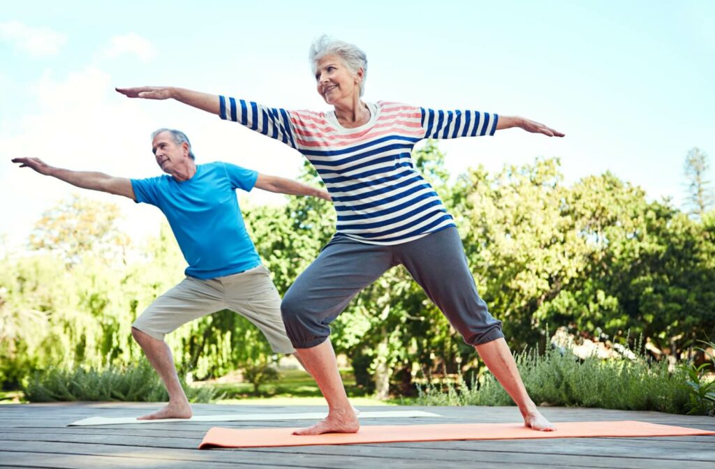 A senior man & woman practicing tai chi to help improve their balance