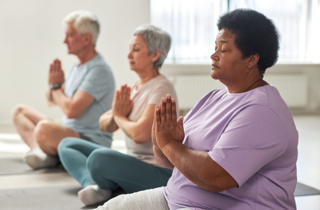 A group of older adults meditating in Lotus pose.