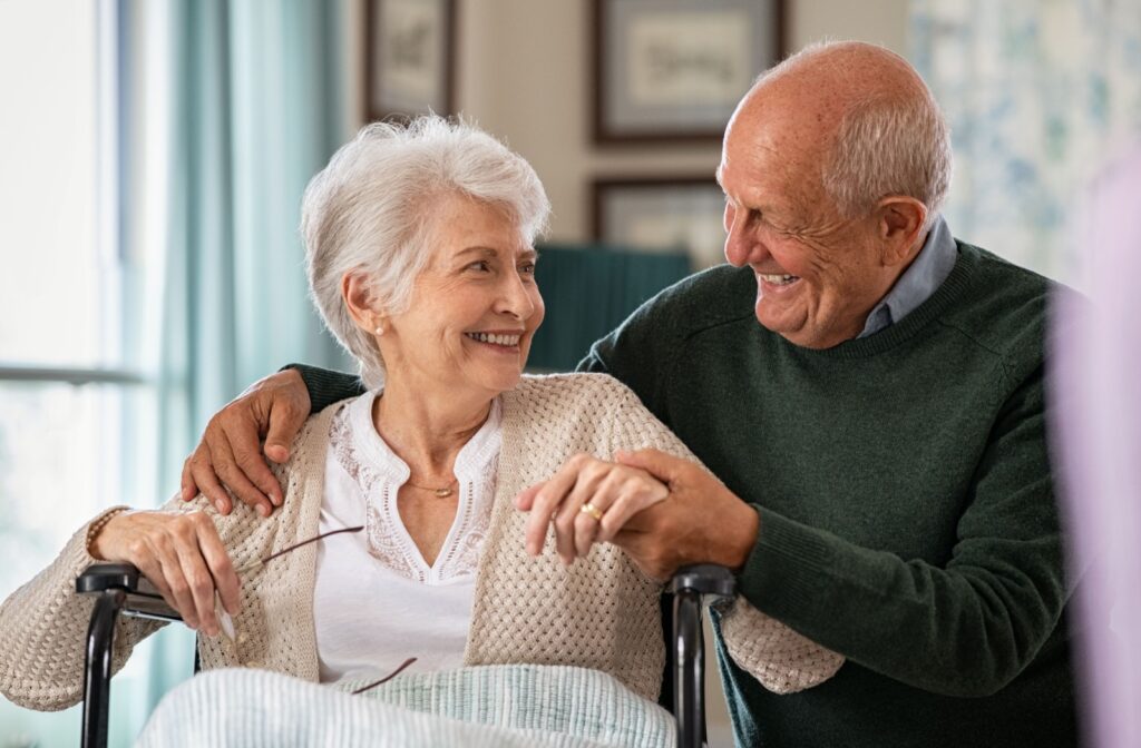 Senior couple staring out a window looking concerned as they ponder the future and potential memory care programs.