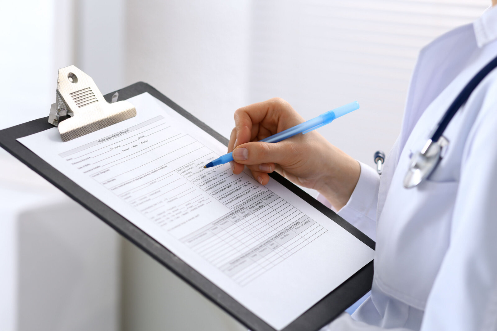 Female doctor filling up medical form.