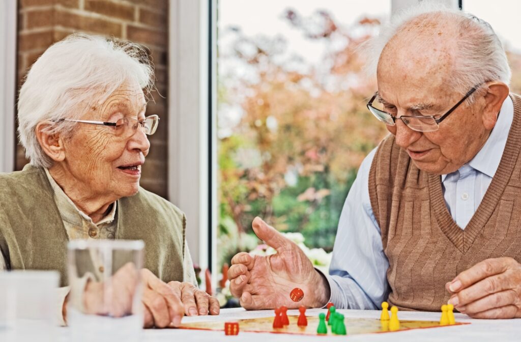 Two older adults playing a board game together at a table.