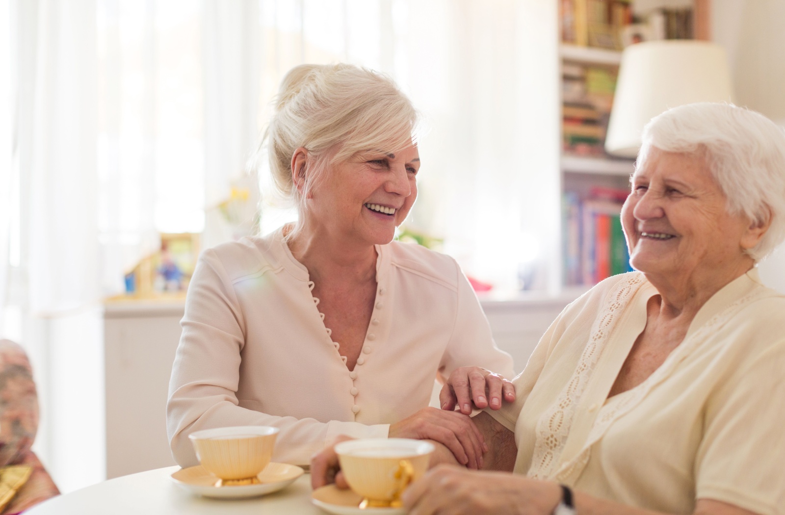 an adult kid having a tea with her senior parent