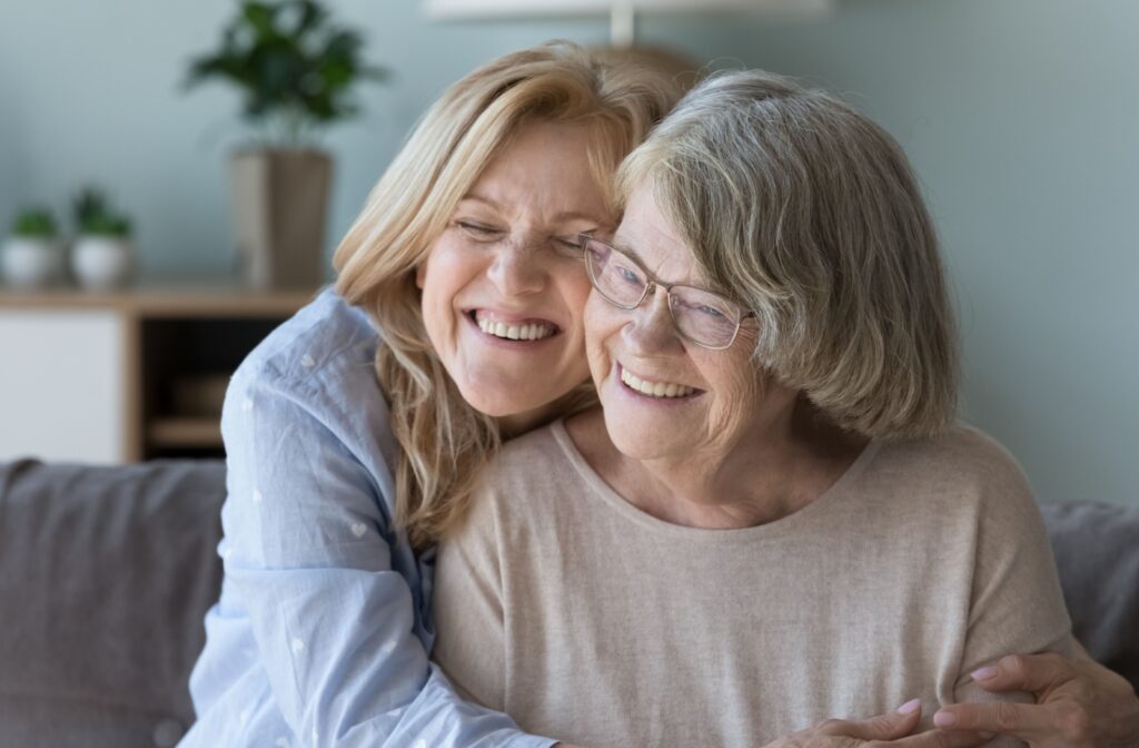 an adult kid hugging her senior parent
