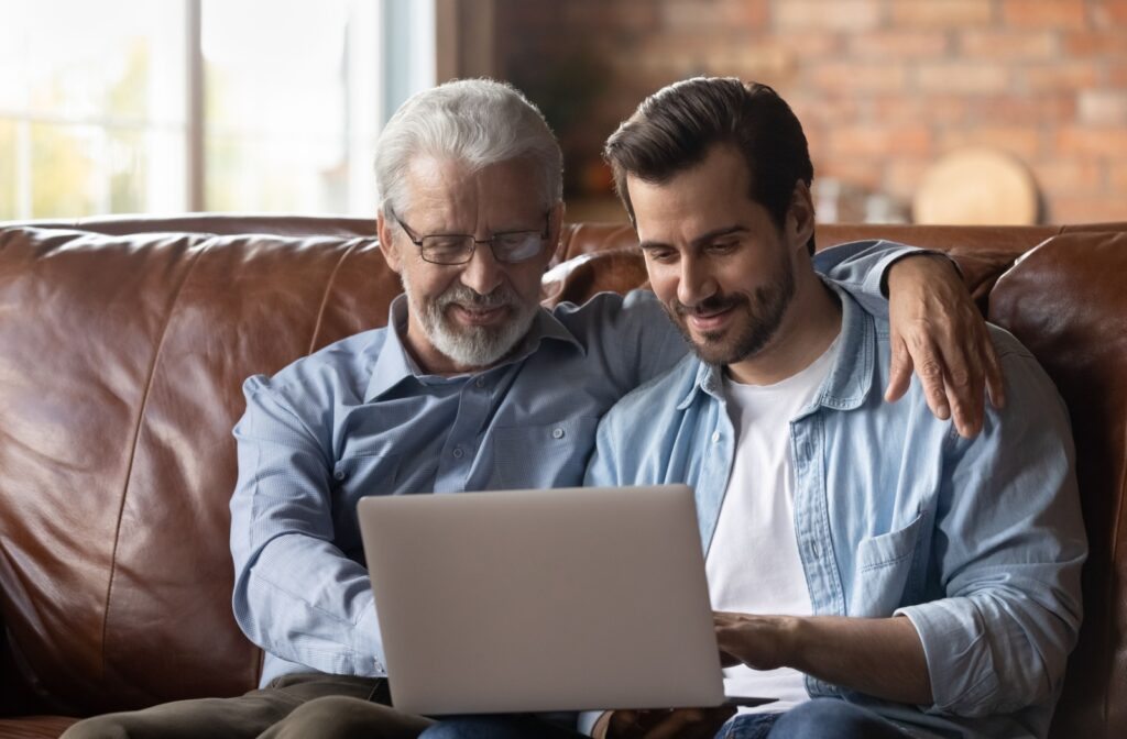 an adult kid helping a senior with the computer