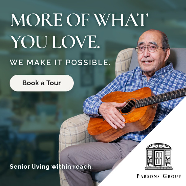 Senior man in a plaid shirt sits with a guitar in a living room; ad copy reads 'More of what you love. We make it possible.' and a 'Book a Tour' button is visible.