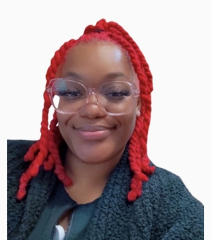 Smiling woman with red braids and clear-framed glasses, wearing a dark jacket against a white background.